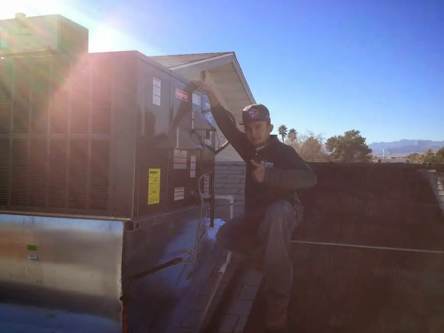 HVAC technician performing Air Duct Cleaning on a rooftop unit in Brooklyn Park